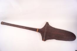 A Polynesian wooden paddle with partially serrated sides,