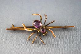 A yellow metal spider bar brooch set with amethyst. Pin and hook fitting. Stamped 9ct. 5.