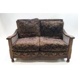A 1920's three piece mahogany and oak Bergere suite: two seater sofa,