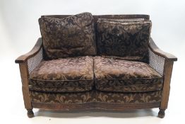 A 1920's three piece mahogany and oak Bergere suite: two seater sofa,