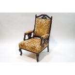 A Victorian mahogany armchair with floral upholstery in relief