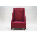 An Edwardian nursing chair of unusual angular form, raised floral patterned deep pink fabric,