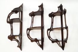 A set of three reproduction mahogany three tier hanging shelves,