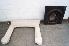 A carved sandstone mantelpiece/fire surround with cast iron grate inset,