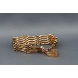 A gold five bar gate bracelet with padlock and safety chain. Stamped LW&C 9ct. 17.