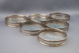 A set of six Sterling and glass bottomed small coasters,