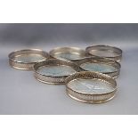 A set of six Sterling and glass bottomed small coasters,