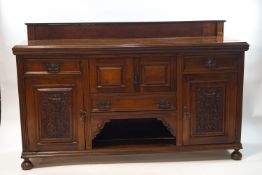 A late Victorian mahogany sideboard with raised back above an arrangement of drawers and hinged
