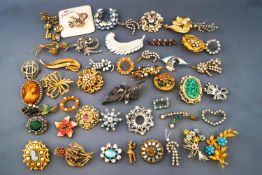 A selection of forty six costume base metal brooches,