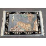 A Chinese rug with a landscape on a grey field, within one wide border with a black field,
