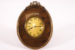 A French gilt metal and tortoiseshell oval bedside clock,