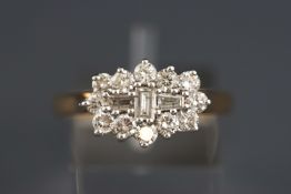 A yellow and white metal boat cluster ring set with round brilliant and baguette cut diamonds.