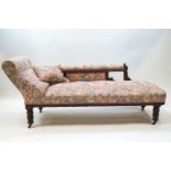 An Edwardian oak chaise longue with turned legs on brass and ceramic casters,