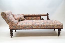 An Edwardian oak chaise longue with turned legs on brass and ceramic casters,