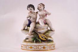 A 19th century Continental porcelain group of two Cherubs, one playing a picolo, on an oval base,