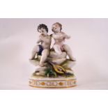 A 19th century Continental porcelain group of two Cherubs, one playing a picolo, on an oval base,