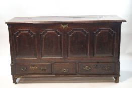 An 18th century oak mule chest with hinged top quadruple panelled front above three drawers,