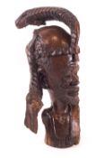 An African carved hardwood bust of a bearded tribal man, signed T Musole to the neck,