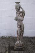 A reconstituted stone figure of a lady wearing Classical robes, holding a water carrier,
