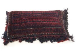 A Middle Eastern tasselled carpet cushion,