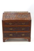 A Victorian Aesthetic Period mahogany bureau, profusely carved with pomegranates,