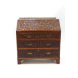 A Victorian Aesthetic Period mahogany bureau, profusely carved with pomegranates,