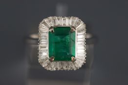 A white metal emerald and diamond cluster ring.