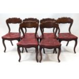 A set of six Victorian mahogany dining chairs on cabriole legs and with red leatherette seats