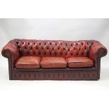 A red leather three seater Chesterfield sofa,