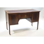 An Edwardian inlaid mahogany writing desk with inset red leather surface over a central drawer