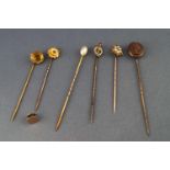 A selection of six assorted stick pins and a single shirt button. All marked for 9ct gold.