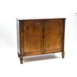 A George IV mahogany linen press with two panelled doors enclosing three sliding shelves,