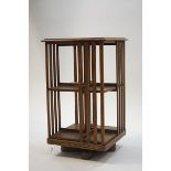 An early 20th century oak revolving book stand with slatted sides,