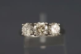 A white metal three stone diamond ring. Set with three round brilliant cut diamonds.