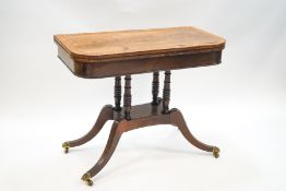 A 19th century cross-banded mahogany tea table on four spindle supports and reeded outswept legs,