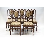 A set of five modern hardwood dining chairs with scrolling floral upholstery