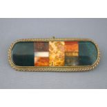 A Scottish agate bar brooch set within a gold plated rope edge mount. Pin and hook fitting. 22.