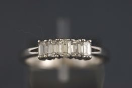 A white metal five stone graduated baguette cut diamond ring. Stated total weight of 0.78 carats.