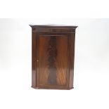 A George III flame mahogany hanging corner cupboard with dentil cornice, 96.