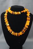 A modern tumble-polished amber bead necklace in transparent and opaque 'butterscotch' colours,