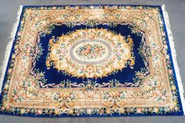 A large Chinese carpet with flowers on a dark blue field 371cm X 278cm