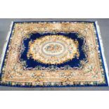 A large Chinese carpet with flowers on a dark blue field 371cm X 278cm