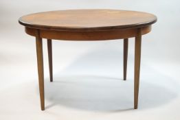 A G-Plan circular teak draw leaf dining table and four G-Plan chairs,