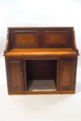 An Edwardian poplar wood desk with two cupboard doors to the raised back and two cupboard doors,