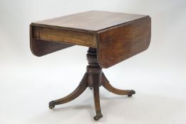 A George IV mahogany Pembroke table on turned column and four splayed legs with brass paw terminals