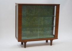 A 1970's display cabinet, the sliding glass doors enclosing two shelves,