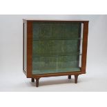 A 1970's display cabinet, the sliding glass doors enclosing two shelves,