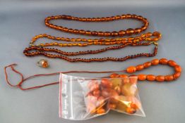 A selection of amber jewellery to include three strung necklaces, a partially strung necklace,