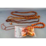 A selection of amber jewellery to include three strung necklaces, a partially strung necklace,