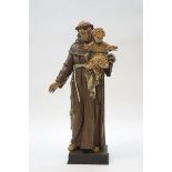 A Czech carved and painted figure of St Anthony holding the infant Jesus,